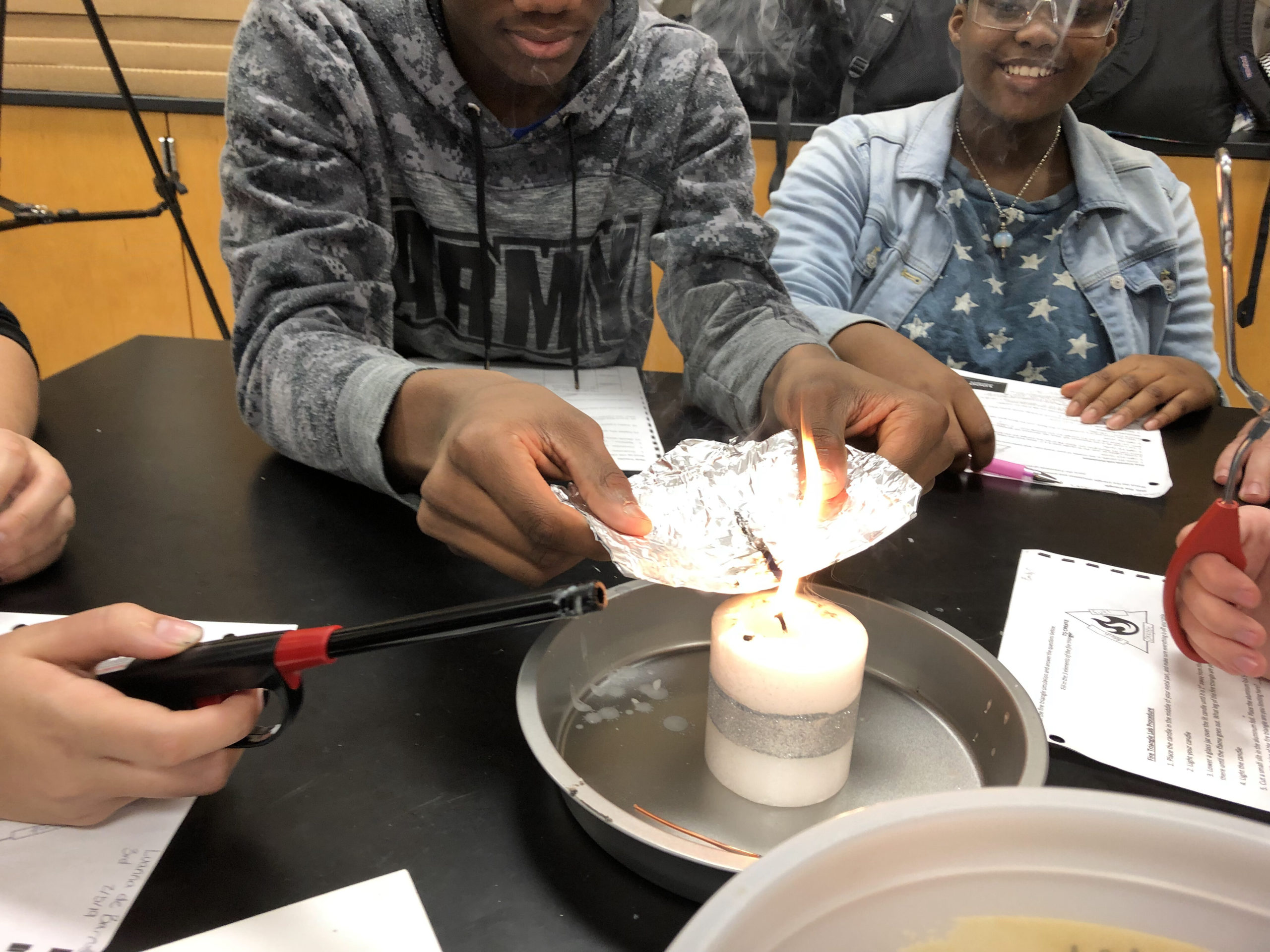 The middle schoolers examined how and why various materials extinguish flames. 