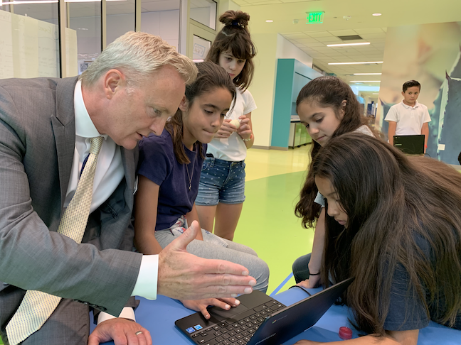 Desert Sands USD Superintendent Scott Bailey discusses a coding and robotics assignment with students in the hallway of Richard R. Oliphant Elementary School, which has a K-5 computer science program.