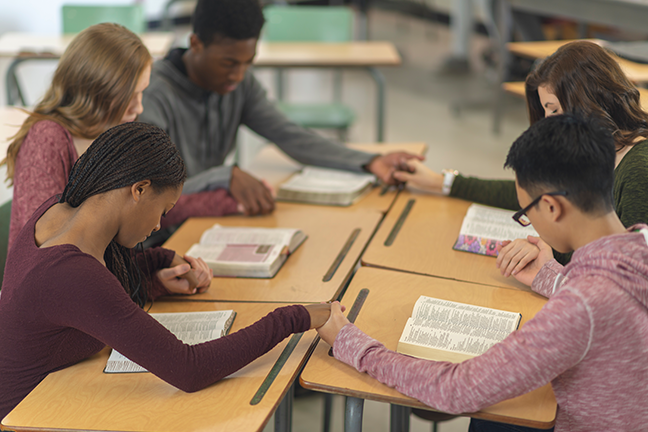 About 30% of students say they regularly wear jewelry or clothing with religious symbols, pray before lunch, invite other students to worship services or a youth group, or leave school during the day to participate in religious activities, according to a new Pew Research Center survey. (gettyimages.com: FatCamera)