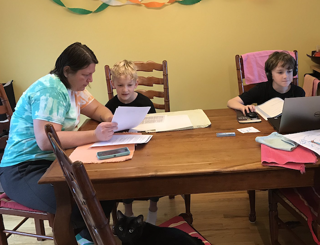 A parent and her children work on online learning assignments during coronavirus school closures in Hamilton County, Tennessee.