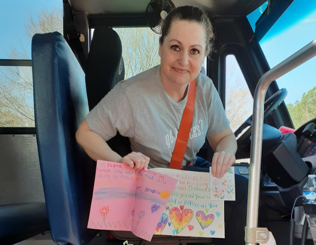 A Gwinnett County Public Schools bus driver who deliver meals while classrooms were closed shows off thank you cards she received from students.
