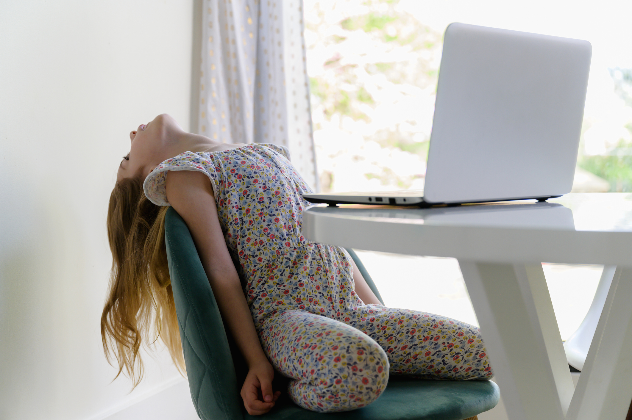 Girl (67) leaning back on chair while remote learning