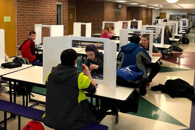 Students eat lunch separated by dividers in Wisconsin's School District of Waupaca.